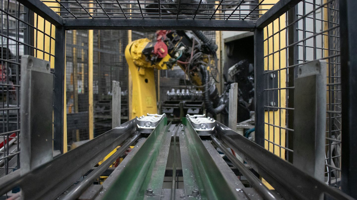 Üretim hattında konveyör bantlarıyla çalışan robotik kol.